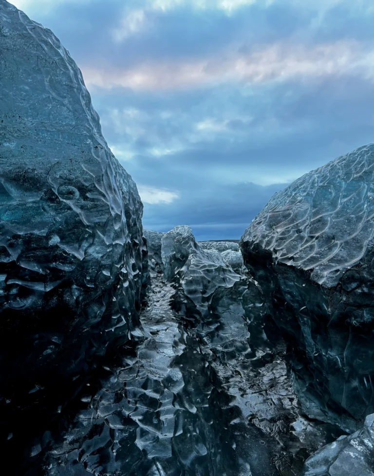 View between two huge chunks of blue ice on Vatnajökull glacier, with a beautiful blue and pink sky